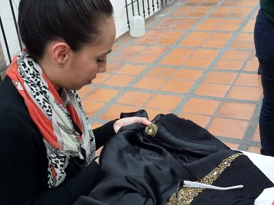 Alumna cosiendo a mano una prenda de satín, 2016.