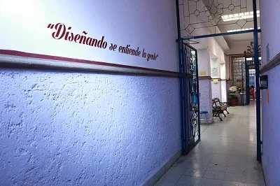 Muro azul con la frase Diseñando se entiende la gente pintada a mano