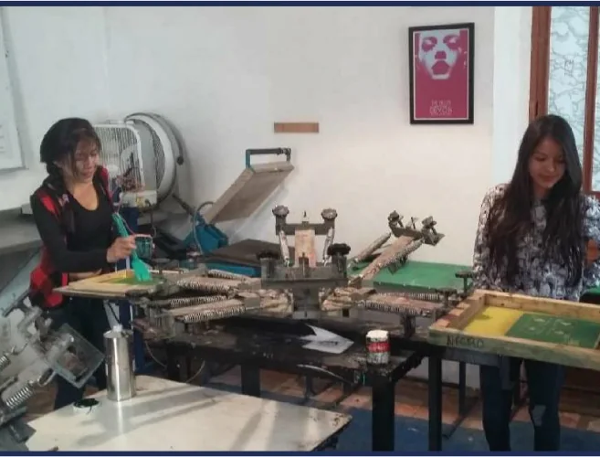 Dos alumnas trabajando en la mesa de serigrafía del taller