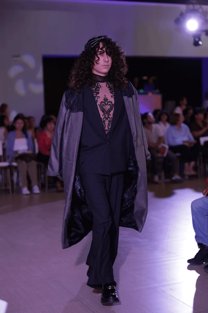 Conjunto negro sobre fondo oscuro, silueta larga.